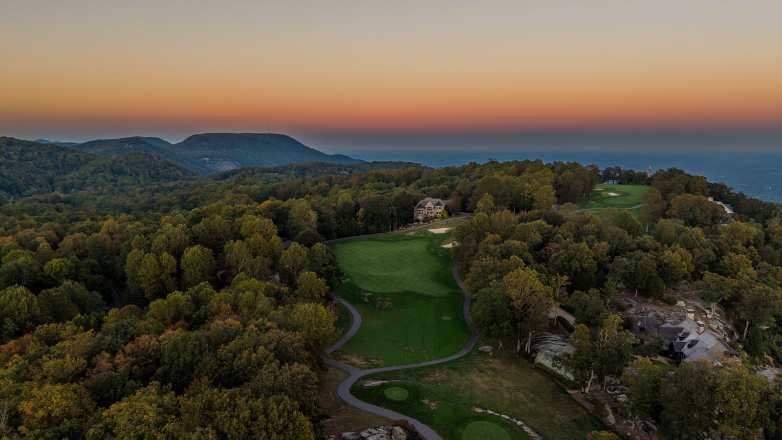 Aerial of the Glassy golf course at sunset, the Blue Ridge and the Upstate beyond
