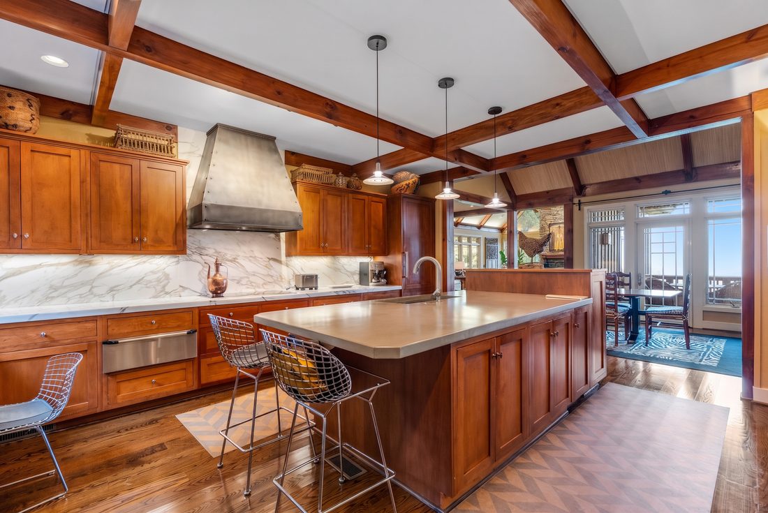 Kitchen island in poured concrete under a hammered-metal hood
