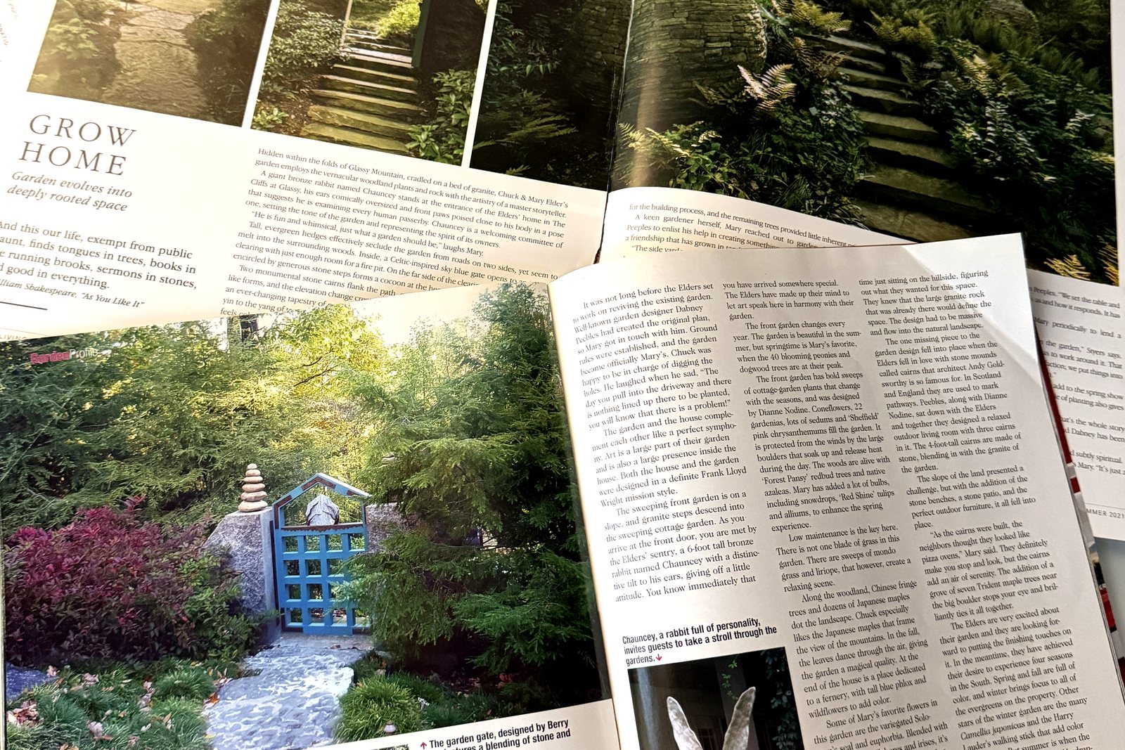 The two published magazine features on the garden, open on a desk